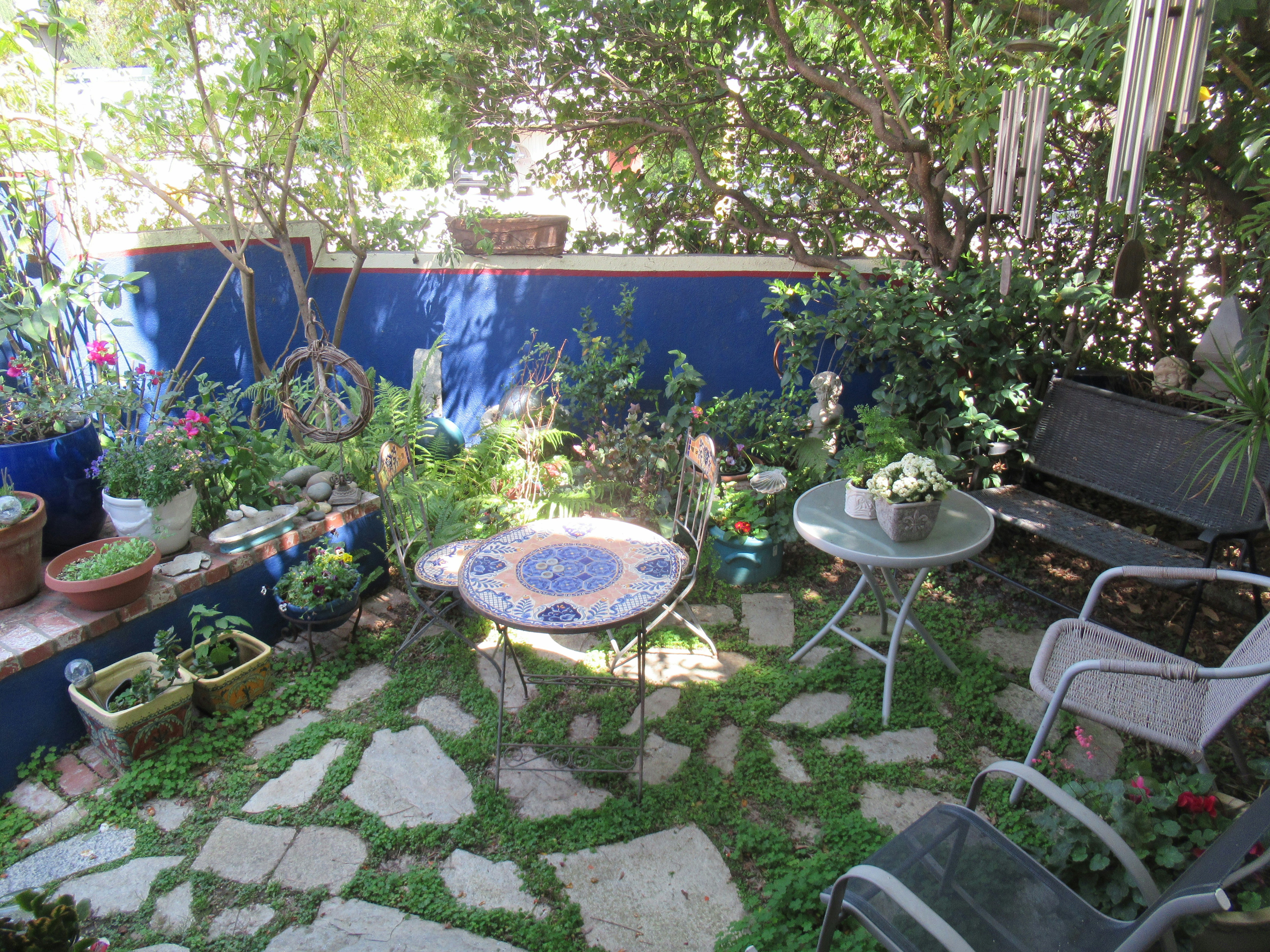 a small garden with a table and chairs